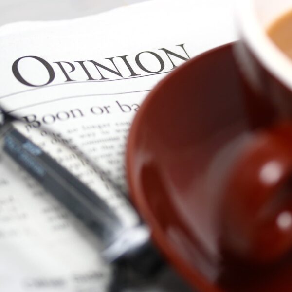 Having A Cup Of Coffee And Looking At The Opinion Section Of The Newspaper
